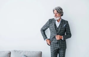 Man over 40 wearing a tailored three-piece suit.