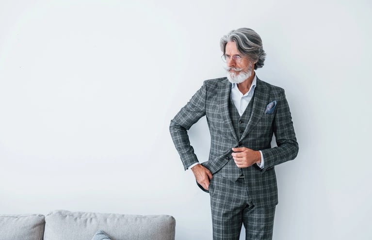 Man over 40 wearing a tailored three-piece suit.Â