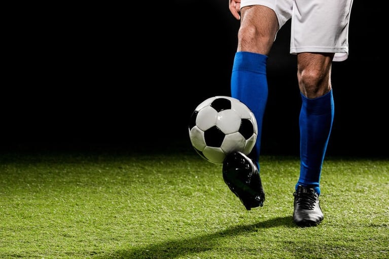 Male football player on a soccer field, preparing to play or control the ball during a match.