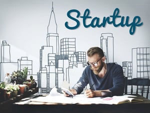 Man planning a startup business at a desk with city skyline background