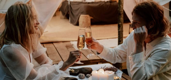 man and woman toasting wine in a rustic venue