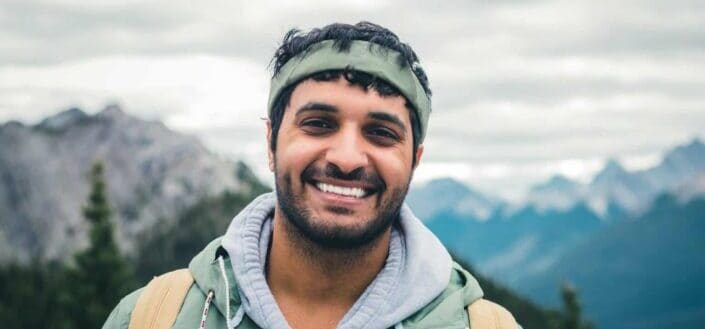 Man in green zip up jacket smiling