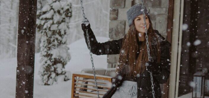 A woman in winter clothes on a swing during winter