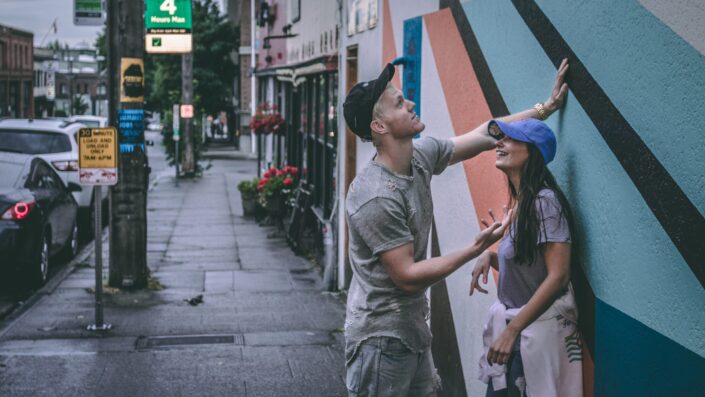 A couple laughing at the side of a street