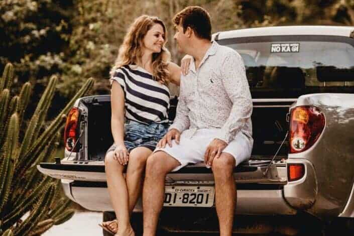 A couple looking at each other while seated at the back of a car