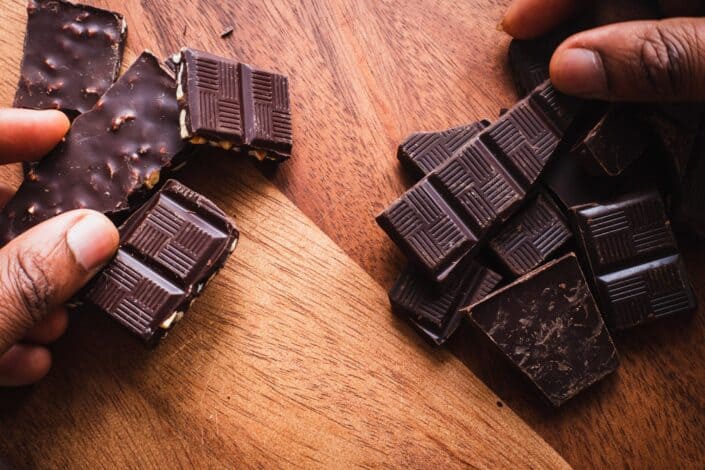 A hand holding blocks of chocolate