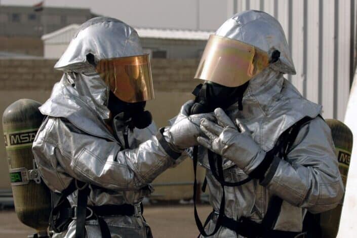 Two uniformed people breathing through oxygen supply