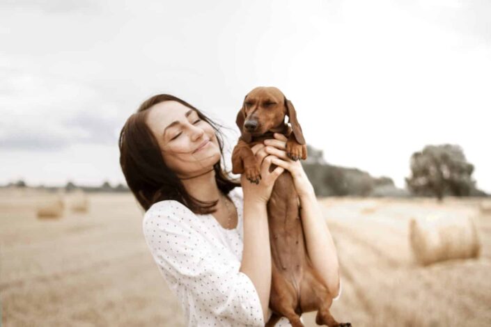 Woman carrying her dog happily