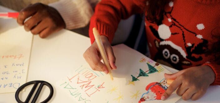 Two kids writing a Christmas letter.