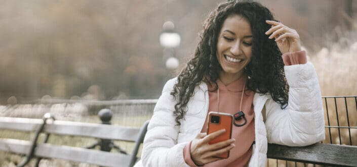 Woman sitting in a bench while texting