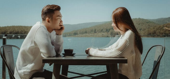 Couple having a romantic date beneath an overlooking lake view.