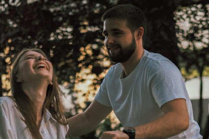 Happy couple having a good time outdoors under shady trees