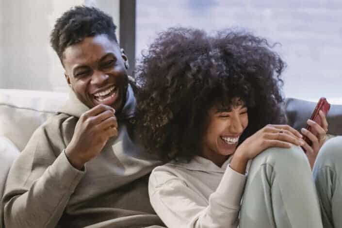 couple on couch with smartphone