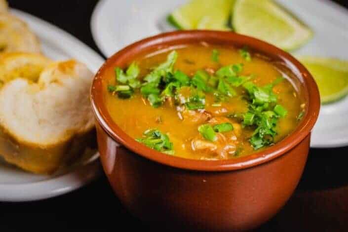 menudo soup in an orange bowl