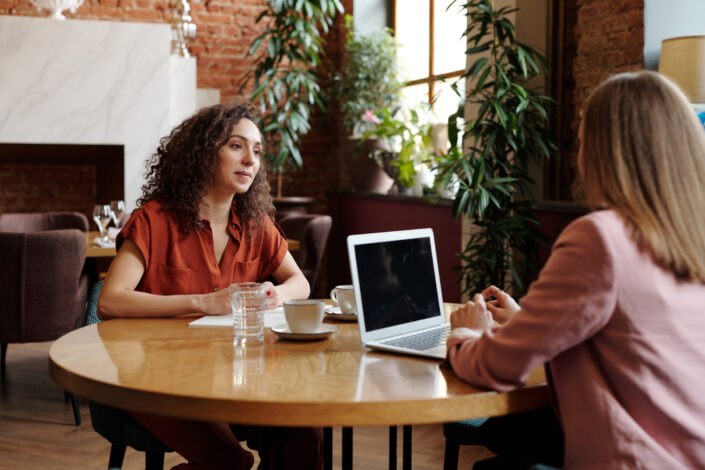 Women with cups of coffee and laptop