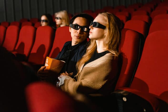 A couple wearing 3d glasses while watching a movie