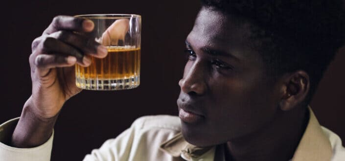 A man drinking liquor in a glass