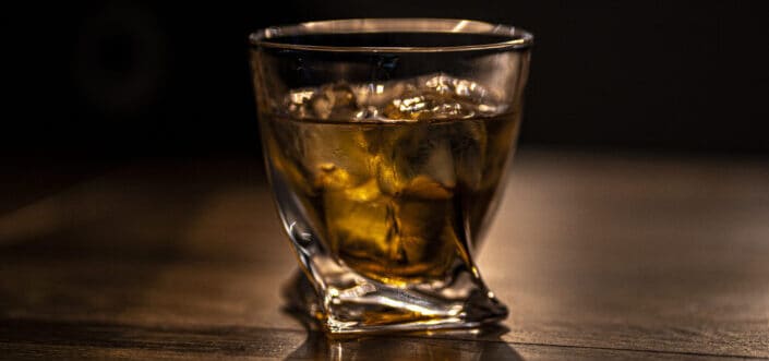 glass of whiskey on a wooden table