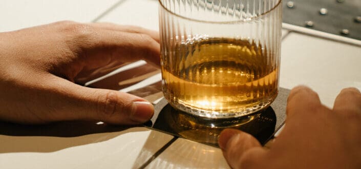 Person holding clear drinking glass