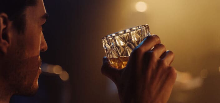 man holding a glass of whisky