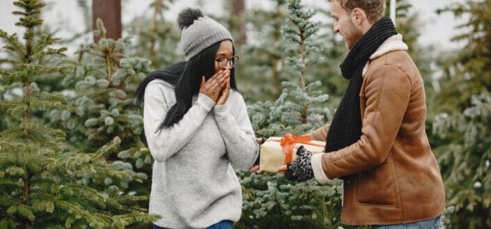 A man surprising his woman with a christmas present