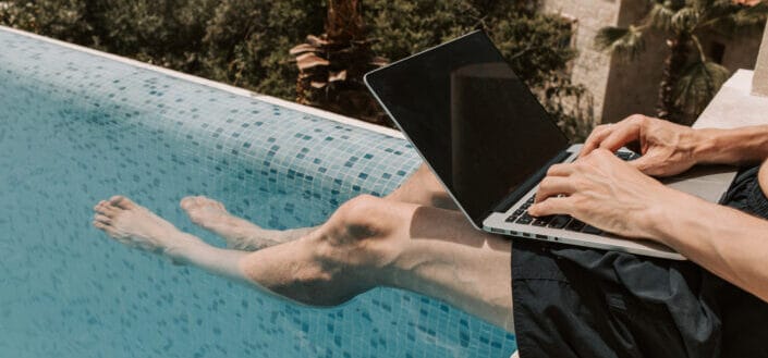 man using black laptop in swimming pool