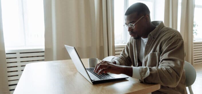 Man using macbook on wooden table