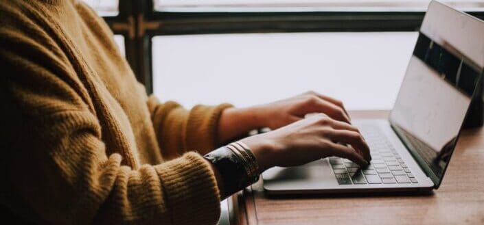 man typing on his laptop