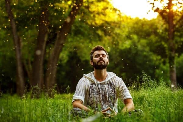 Man sitting in a lotus asana pose, and embracing state of relaxation. With serene expression on face