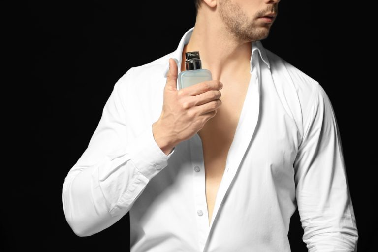Man applying cologne as part of his daily grooming routine