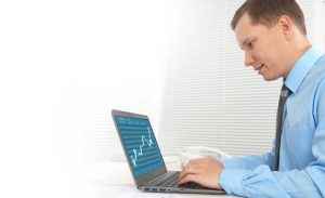 A man analyzing prediction market charts on a laptop.